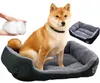 A Shiba Inu dog sits in a dog bed, with a hand holding stuffing next to it and another dog bed in the background. Anteprima dell’immagine prodotto