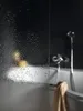 A person is visible through a shower door with water droplets, with a bathtub and faucet in the background. Produktbild-Vorschau