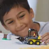 A young boy is playing with a toy front loader and a small fence structure. Náhľad obrázku produktu