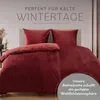 A bed with red bedding, styled for a cozy winter atmosphere. Voir les images du produit