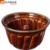 A brown ceramic gugelhupf mold is shown against a white background. The mold has a fluted design and a central tube. Voir les images du produit