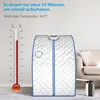 A portable steam sauna set up in a living room next to a couch. Náhľad obrázku produktu
