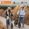 A couple is posing with their electric bikes in an outdoor setting with dry reeds. Voir les images du produit