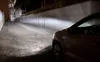 A car's headlights illuminate a paved pathway at night. Podgląd zdjęcia produktu