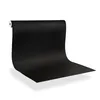 A roll of black adhesive film is shown unrolling onto a white surface, creating a seamless backdrop. Produktbild-Vorschau