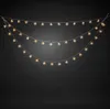 Three strings of snowflake-shaped LED lights are hung in a curved arrangement against a black background. Produktbild-Vorschau