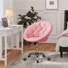 A pink tufted desk chair is shown next to a white desk with a laptop and a plant in a room with a bed in the background. Produktbild-Vorschau
