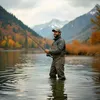 A man is fishing in a lake during autumn with mountains and colorful trees in the background. Produktbild-Vorschau