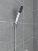 A close-up shot of a modern hand shower head mounted on a tiled wall. Produktbild-Vorschau