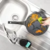 A hand is cleaning a small frying pan with multiple circular indentations in a kitchen sink. Anteprima dell’immagine prodotto