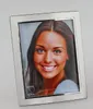 A silver picture frame with a woman's portrait inside, set against a light gray background. Produktbild-Vorschau