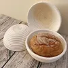 Three round proofing baskets for bread, one containing a loaf of bread, placed on a wooden surface. Produktbild-Vorschau