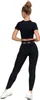 A woman is shown from the back wearing black leggings and a black crop top, with white sneakers. Produktbild-Vorschau