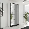 A modern white wardrobe with black accents and mirrored doors is shown in a brightly lit room with plants. Voir les images du produit