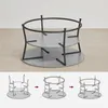 A two-tiered round coffee table with a metal frame and gray surfaces, shown from different angles and in an assembly illustration format. Produktbild-Vorschau