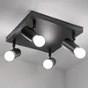 A black, square ceiling light fixture with four adjustable spotlights is shown against a white ceiling and wall. Voir les images du produit