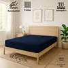 A bedroom scene with a bed featuring a navy blue fitted sheet. Produktbild-Vorschau