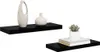 Two black floating shelves are displayed against a white background. The top shelf holds a textured beige vase and a small white vase. The bottom shelf displays a small potted succulent plant resting on two books. Náhled obrázku produktu