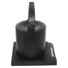 A black electric kettle with a handle sits on its charging base. Podgląd zdjęcia produktu