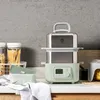 A kitchen counter with a multi-tiered steamer, jars of pasta, and a green ceramic dish. Produktbild-Vorschau