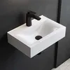 A white ceramic sink with a black faucet mounted on a dark wall. Produktbild-Vorschau