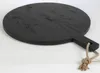 A black round wooden serving board with a handle and a rope loop, placed on a white background. Anteprima dell’immagine prodotto