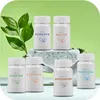 Several small white bottles with labels are arranged on a rock and a surface, with green leaves in the background. Produktbild-Vorschau