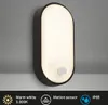 A wall-mounted outdoor light fixture with a motion sensor. Anteprima dell’immagine prodotto