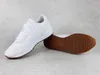 A pair of white Puma sneakers with brown soles are displayed on a light gray surface. Produktbild-Vorschau
