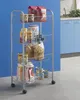 A silver metal rolling cart filled with groceries and pantry items, placed against a blue wall in a kitchen setting. Produktbild-Vorschau