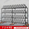 A heavy-duty, multi-tiered shelving unit filled with hexagonal dumbbells, placed on a concrete floor with cracked sections and glowing embers at the base of the supports. Voir les images du produit