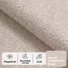 A close-up of a beige boucle fabric, with icons and text describing its features. Produktbild-Vorschau