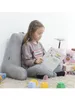 A young girl is sitting on a carpet, leaning against a large gray pillow, and reading a book. There are colorful building blocks scattered around her. Anteprima dell’immagine prodotto
