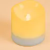 A close-up of a LED solar candle with a yellow top fading to gray at the bottom, set against a light orange background. Produktbild-Vorschau