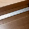 A close-up view of a silver bar with fine lines running horizontally, set against a wooden background. Produktbild-Vorschau