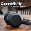 A close-up shot of black Sony headphones resting on a wooden surface. Podgląd zdjęcia produktu
