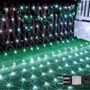 A net of white lights draped over a wooden fence and extending onto a green lawn, decorated with Christmas ornaments. Produktbild-Vorschau
