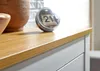A close-up view of a wooden countertop with a decorative item and a calendar. Náhľad obrázku produktu