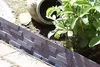 A garden border with a brick pattern is shown next to a plant and a pot. Produktbild-Vorschau