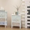 Two white wooden bedside tables with drawers, decorated with French-style text and designs, are placed next to each other against a plain wall. The table on the right has a vase with dried branches and two small jars with candles on top. Náhľad obrázku produktu