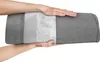 Hands holding a gray lumbar support pillow with a white mesh section. Produktbild-Vorschau
