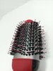 A close-up shot of a round hairbrush with black bristles and red tips, against a white background. Voir les images du produit