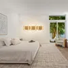 A bedroom with a bed, a large window overlooking trees, and a modern wall lamp. Anteprima dell’immagine prodotto