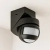 A black motion detector with a pir sensor mounted on a textured white ceiling. Náhľad obrázku produktu