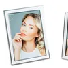 A close-up shot of a silver and white photo frame with a picture of a woman inside, set against a light gray and white background. Produktbild-Vorschau