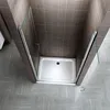 A modern shower enclosure with a glass door and a white shower tray, set against tiled walls and a tiled floor. Produktbild-Vorschau