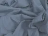 A close-up view of wrinkled, dark blue jersey fabric. Produktbild-Vorschau