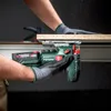 A person wearing work gloves is using a cordless jigsaw to cut a piece of wood, with sawdust flying. Voir les images du produit