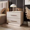 A modern bedside table with two drawers and LED lighting is shown next to a bed in a bedroom setting. A lamp and two perfume bottles are on top of the table. Produktbild-Vorschau