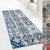 A long runner rug with a tiled pattern is laid out on a white wooden floor. Produktbild-Vorschau